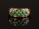 a gold ring with emeralds and diamonds
