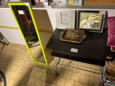 une petite table sur laquelle se trouvent un miroir et un panier