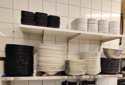 de nombreuses assiettes et bols empilés sur les étagères de la cuisine