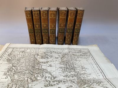 quatre livres sur une table sur laquelle se trouve une carte du monde