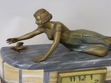a statue of a woman laying on top of a clock