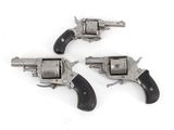three old revolvers are sitting on a white surface with a white background