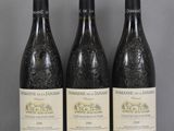 trois bouteilles de vin posées sur une table en verre