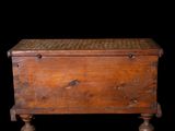 an old wooden chest with a woven top on a black background