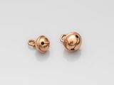 une paire de boucles d'oreilles en forme de boule plaquées or sur fond blanc