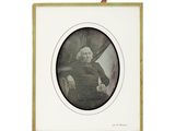 une vieille photo d'un homme assis sur une chaise, tenant une batte de baseball