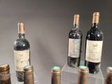 several bottles of wine are lined up on a clear shelf