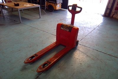 a red forklift sitting on the floor in a garage