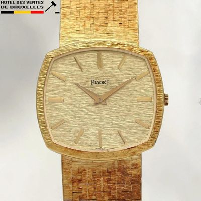 une montre-bracelet en or avec un cadran blanc et un bracelet en or