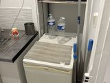 une petite cuisine équipée d'un réfrigérateur et d'un micro-ondes
