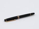 a black and gold pen sitting on top of a white surface