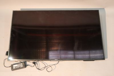 a flat screen tv sitting on a table with a remote