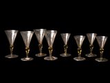 six verres à vin sont alignés sur un fond noir