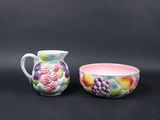 two bowls and a pitcher on a black background