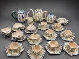 many cups and saucers and a teapot on the table