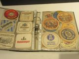 un livre ouvert sur lequel sont posés plusieurs sous-verres à bière