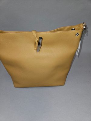 beige leather purse with zippers on a grey background