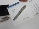 a person holding a pen and a card with a picture on it