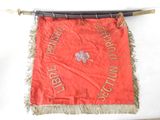 a red banner hanging on a wall with a wooden pole