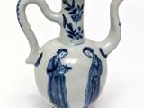 a blue and white vase with two people on it