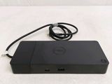 the dell laptop is sitting on a white surface with a cord attached