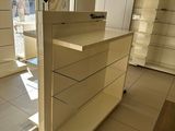 a white counter in the middle of a store with lots of drawers