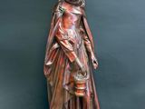 a statue of a woman holding a bucket on a wooden table