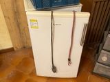 un réfrigérateur blanc sur lequel est posée une corde
