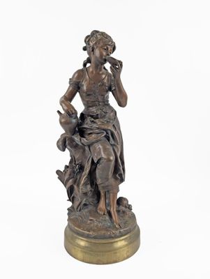 bronze statue of a woman sitting on a rock with a dog