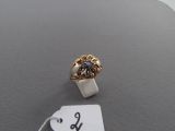 a gold ring with a flower on it and a price tag