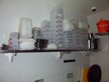 many cups and bowls stacked on a shelf in the kitchen