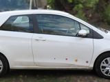a picture of a small white car parked on the side of the road