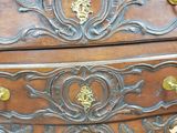 a wooden chest of drawers that has gold hardware on it