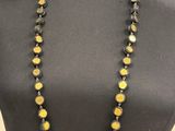 a black mannequin with yellow beads and black beads