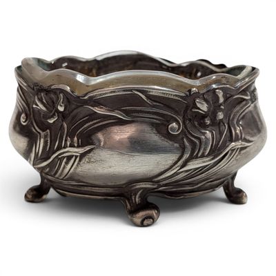 an antique silver bowl on a stand on a white surface