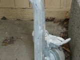 a metal pipe that is sitting next to a cement wall