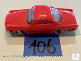 une petite voiture rouge posée sur une feuille de papier bleue