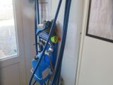 a blue hose attached to a wall next to a window