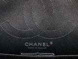 a close up of a black chanel bag with a circular logo on it