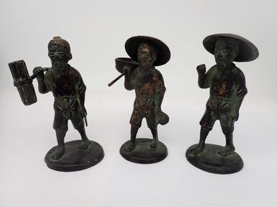 trois figurines en bronze représentant des hommes asiatiques portant des chapeaux et des armes