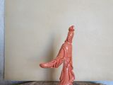 une figurine représentant une femme debout au sommet d'un rocher