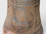 a brown vase with a bird sitting on top of it