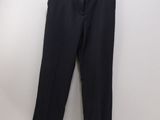 black pants hanging on a hanger against a white wall