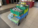 a shopping cart filled with drinks and sodas in a store