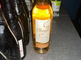 several bottles of wine sit on a table with a cell phone next to them