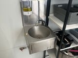 a stainless steel sink in the corner of a kitchen