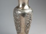 a silver vase that is sitting on a table