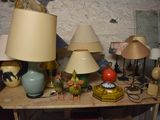 a table with a bunch of lamps and a clock on it