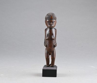 une petite statue en bois représentant un garçon coiffé d'un chapeau