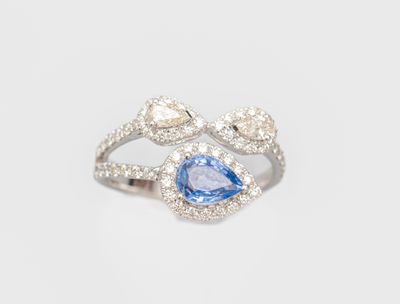 a close up of a diamond and blue sapphire ring on a white background